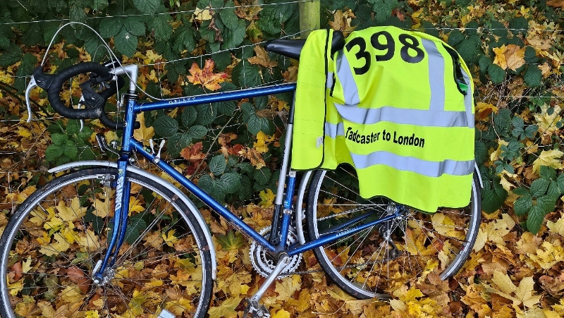 Bike with a yellow tabard with the number 398 on it, and the words: Tadcaster to London 