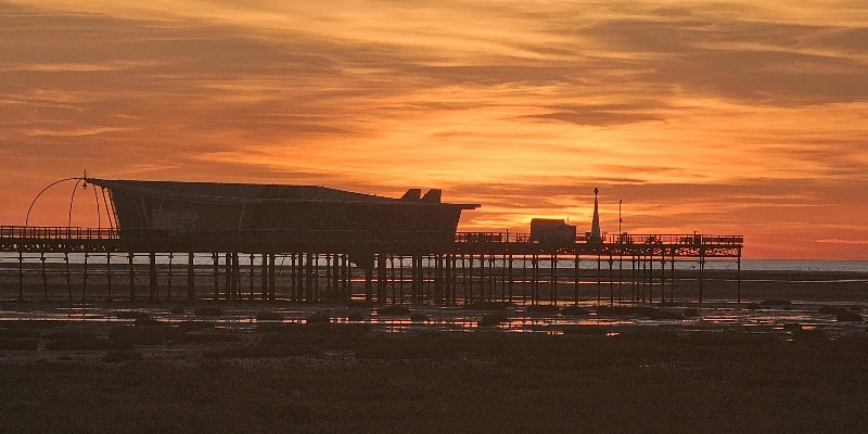 A silhouette of Southport pier at sunset