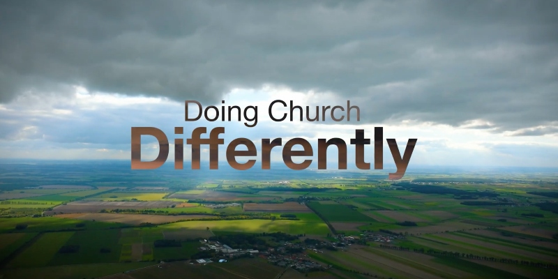 An aerial shot of lots of fields which contains the words "Doing Church Differently"