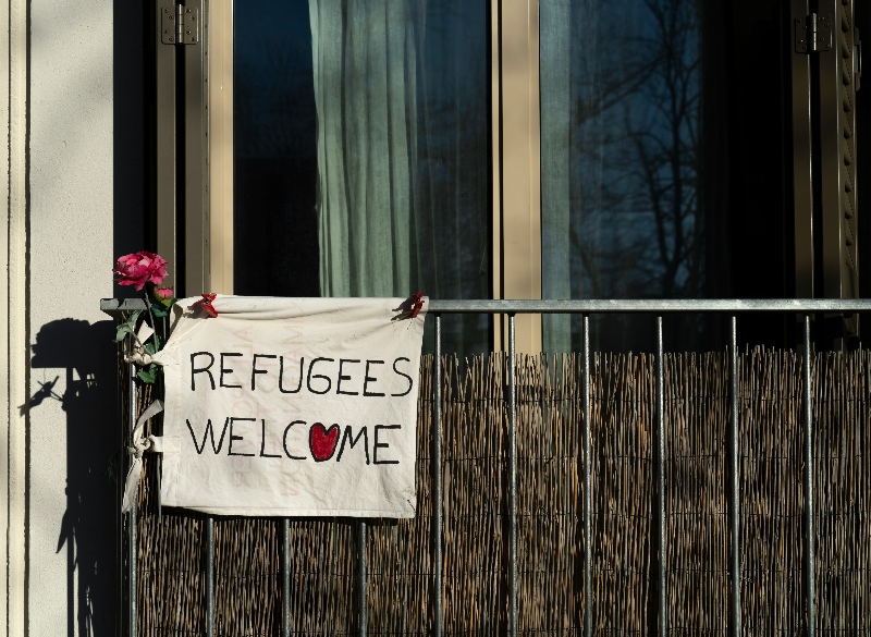 Towel with words "Refugees Welcome" attached to an appartment balcony. The word 'o' is a heart
