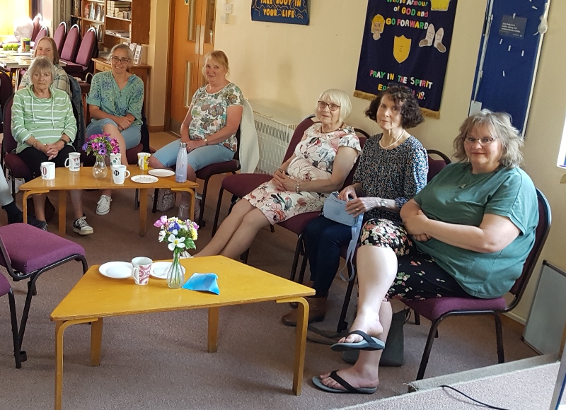 7 people at the small church hub sat on chairs looking at the camera