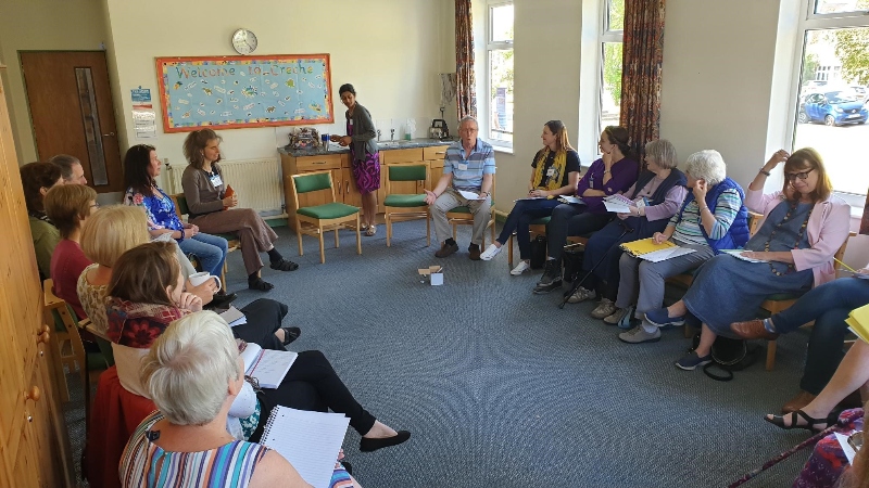 Tonys Hall leading a session - people are sat on chairs around the edge of a room