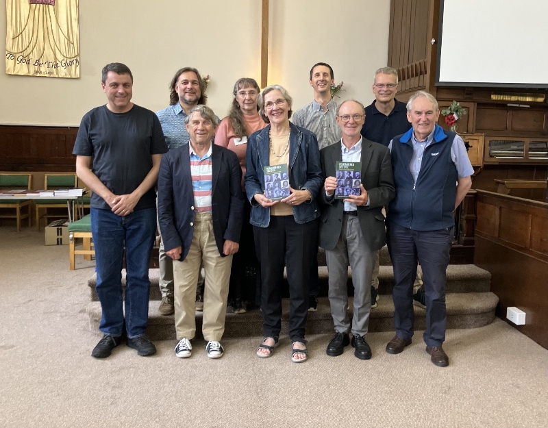 Karen E Smith presentation - Karen holds a copy of her new book, and is stood alongside eight members of the Baptist Historical Society