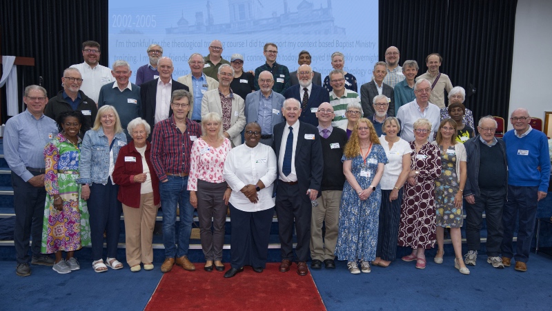 Former Spurgeon's staff - A large group of people posing together for a group photograph on a stage indoors.